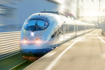 Electric passenger train drives at high speed departs from the platform